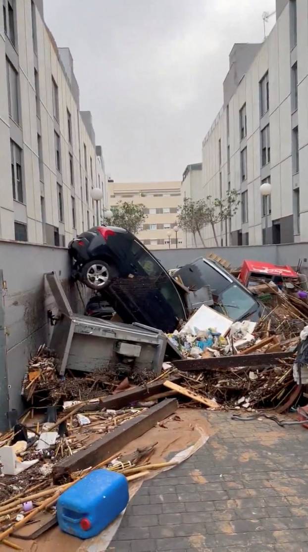 Damaged vehicles and debris are seen piled up after torrential rains and flooding in Paiporta, Valencia