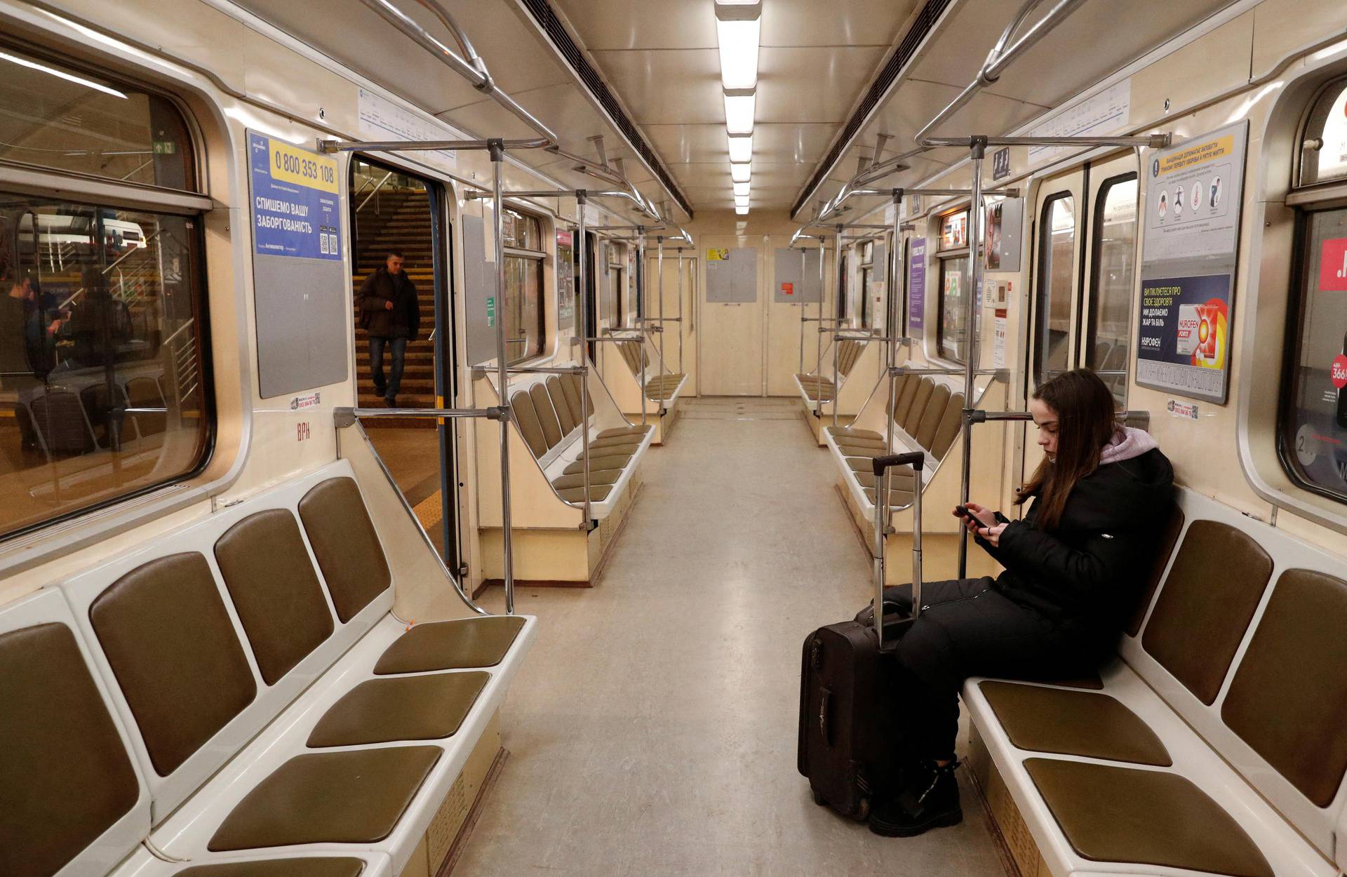 A woman use a smartphone while riding the subway, after Russian President Vladimir Putin authorized a military operation in eastern Ukraine, in Kyiv