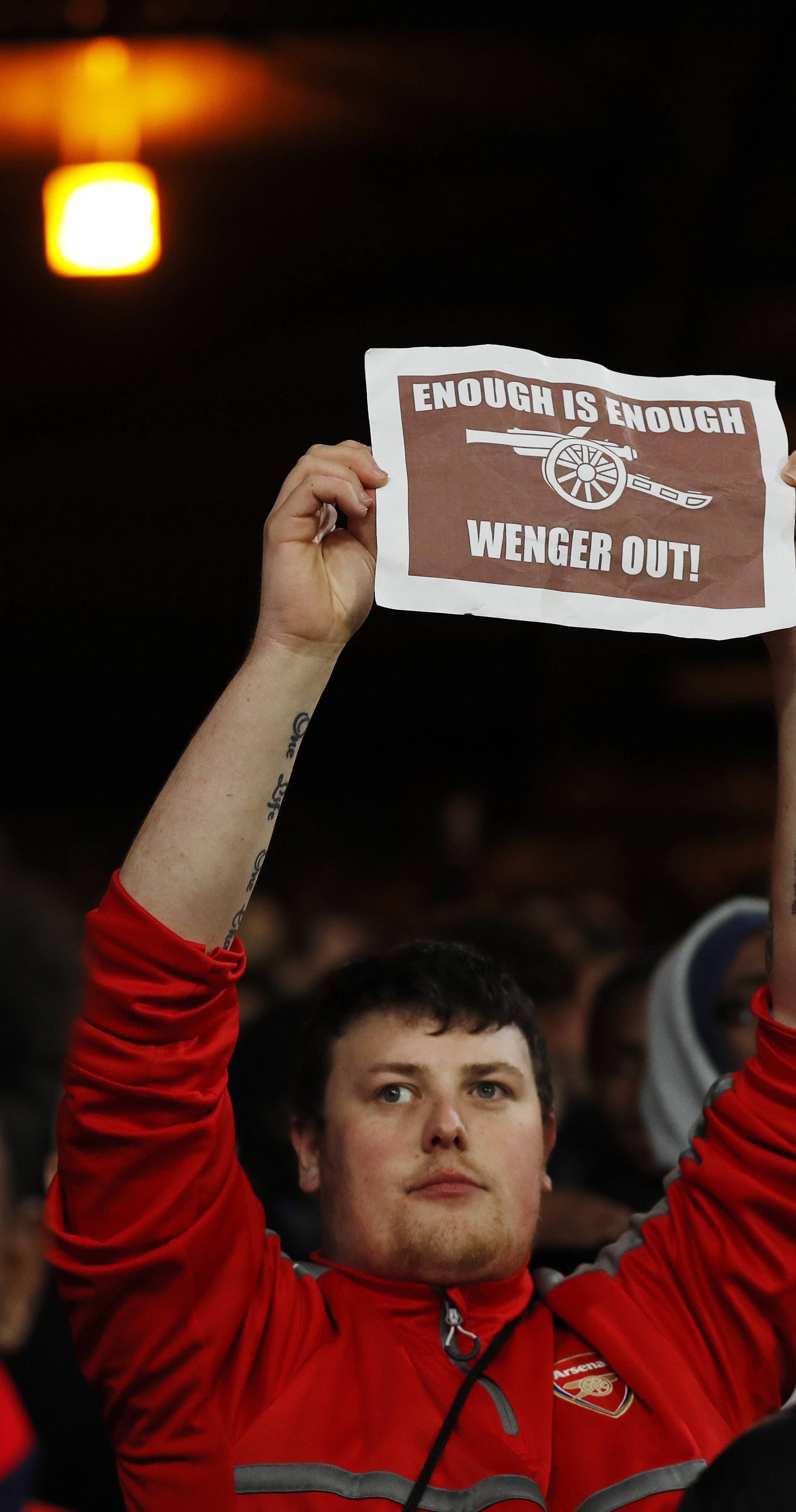 Arsenal fan holds up a message directed at manager Arsene Wenger