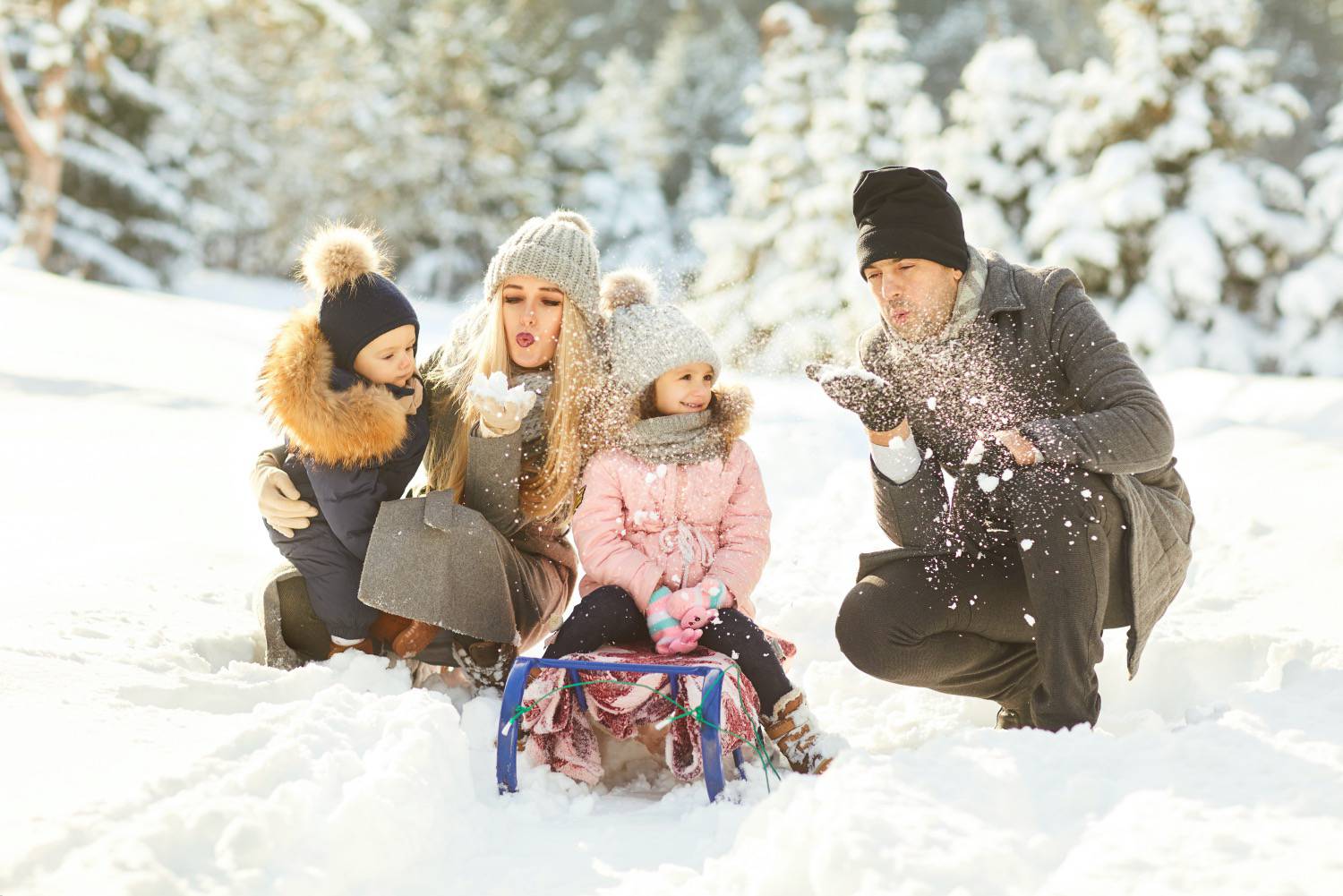 Couple with kids in winter park having fun