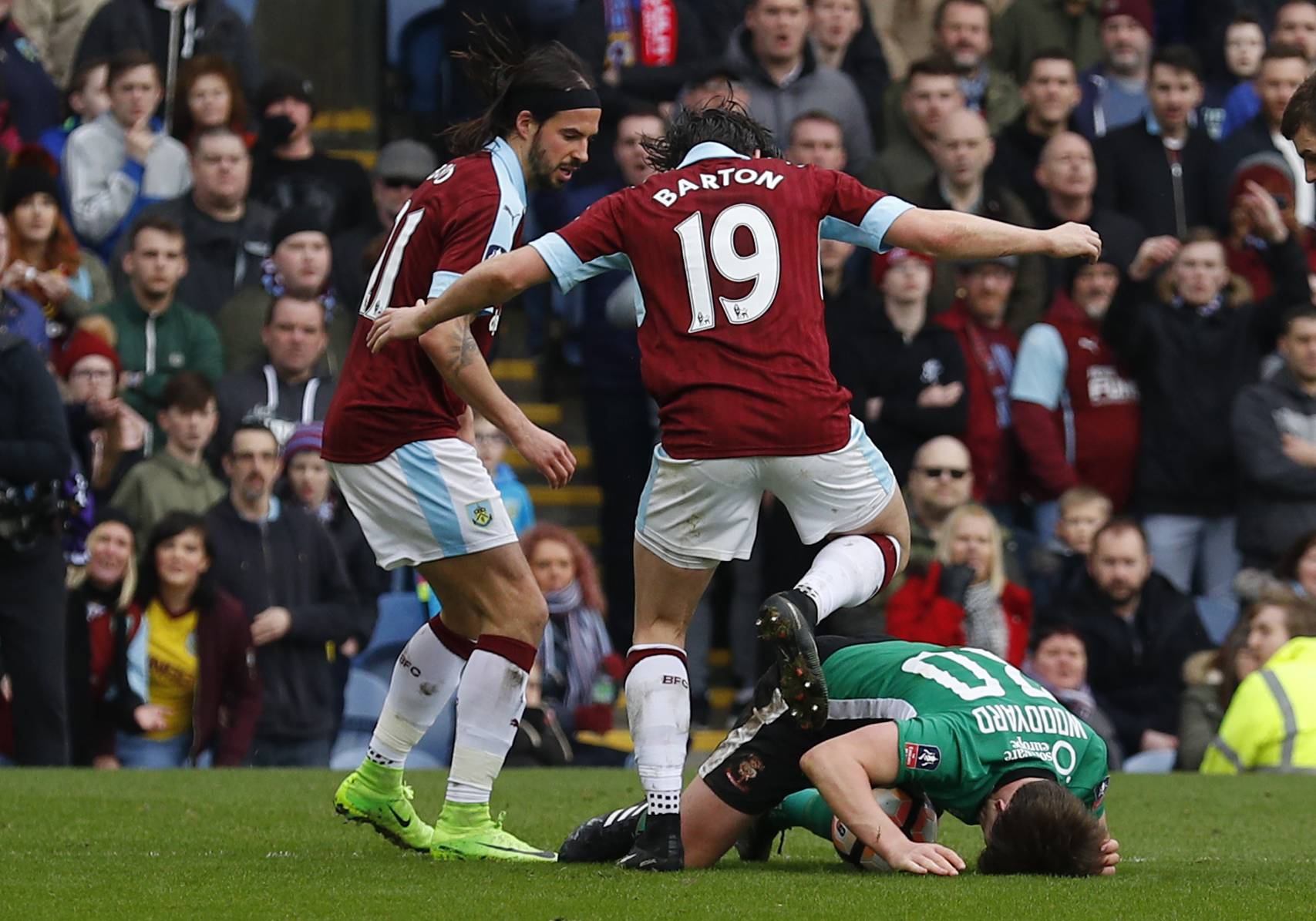 Burnley's Joey Barton clashes with Lincoln's Alex Woodyard as George Boyd looks on