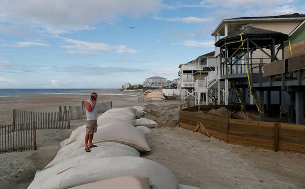 Dennis Kernodle talks on the phone during storm preparations of his oceanfront home ahead of the arrival of Hurricane Florence in Ocean Isle Beach