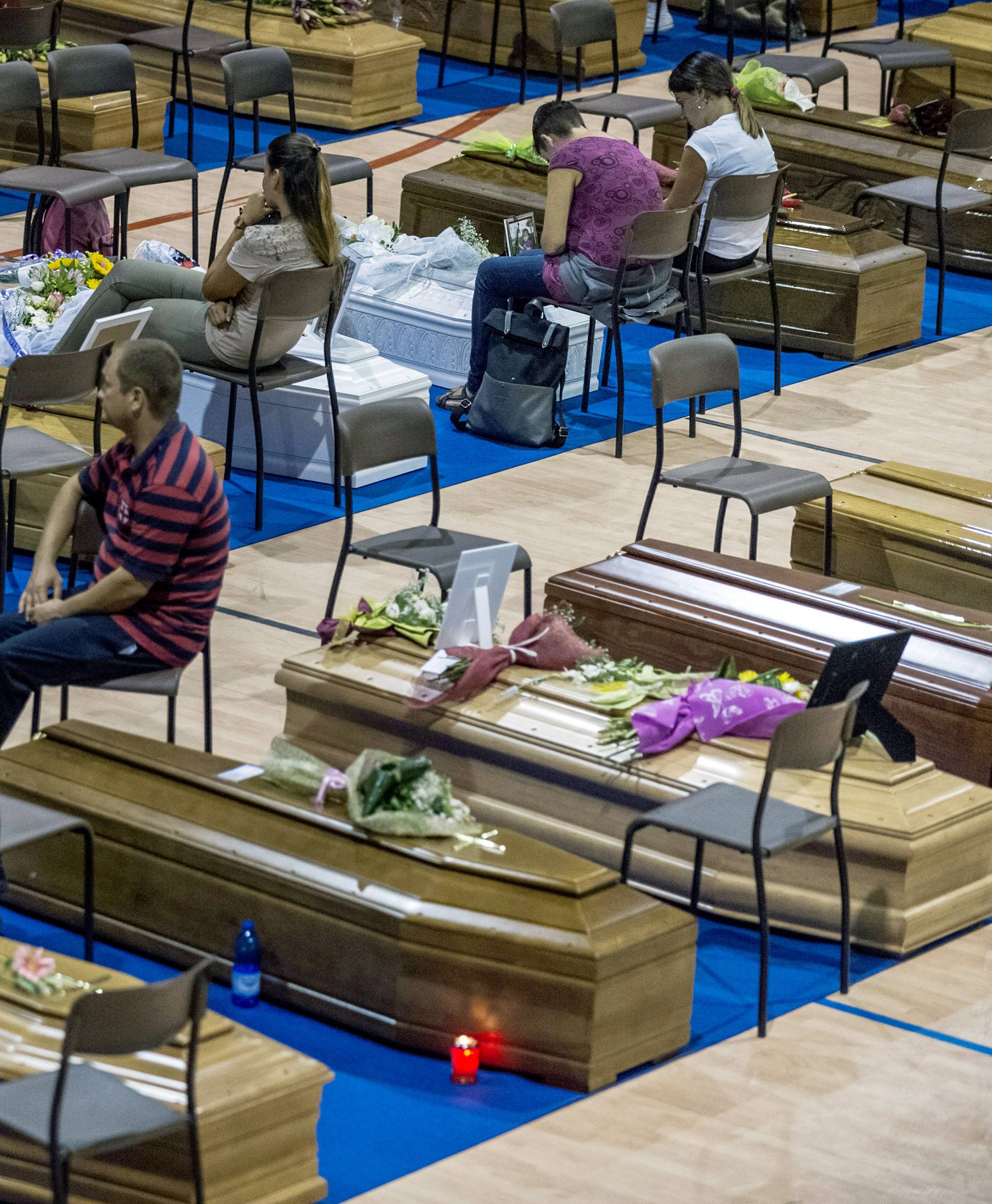 Coffins of some of the victims of the earthquake in central Italy are seen inside a gym in Ascoli Piceno