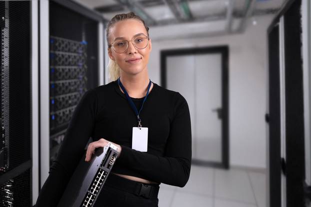 Smiling,Professional,Technician,Holding,Network,Equipment,In,A,Modern,Server