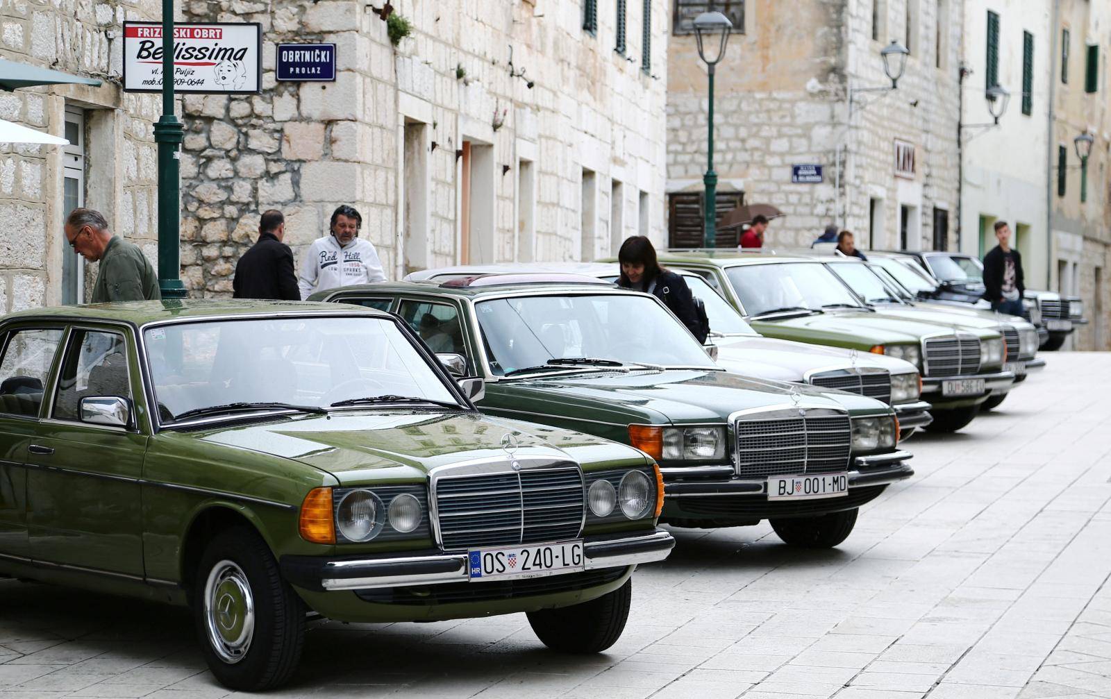 A woman looks at old-timer Mercedes cars in Imotski