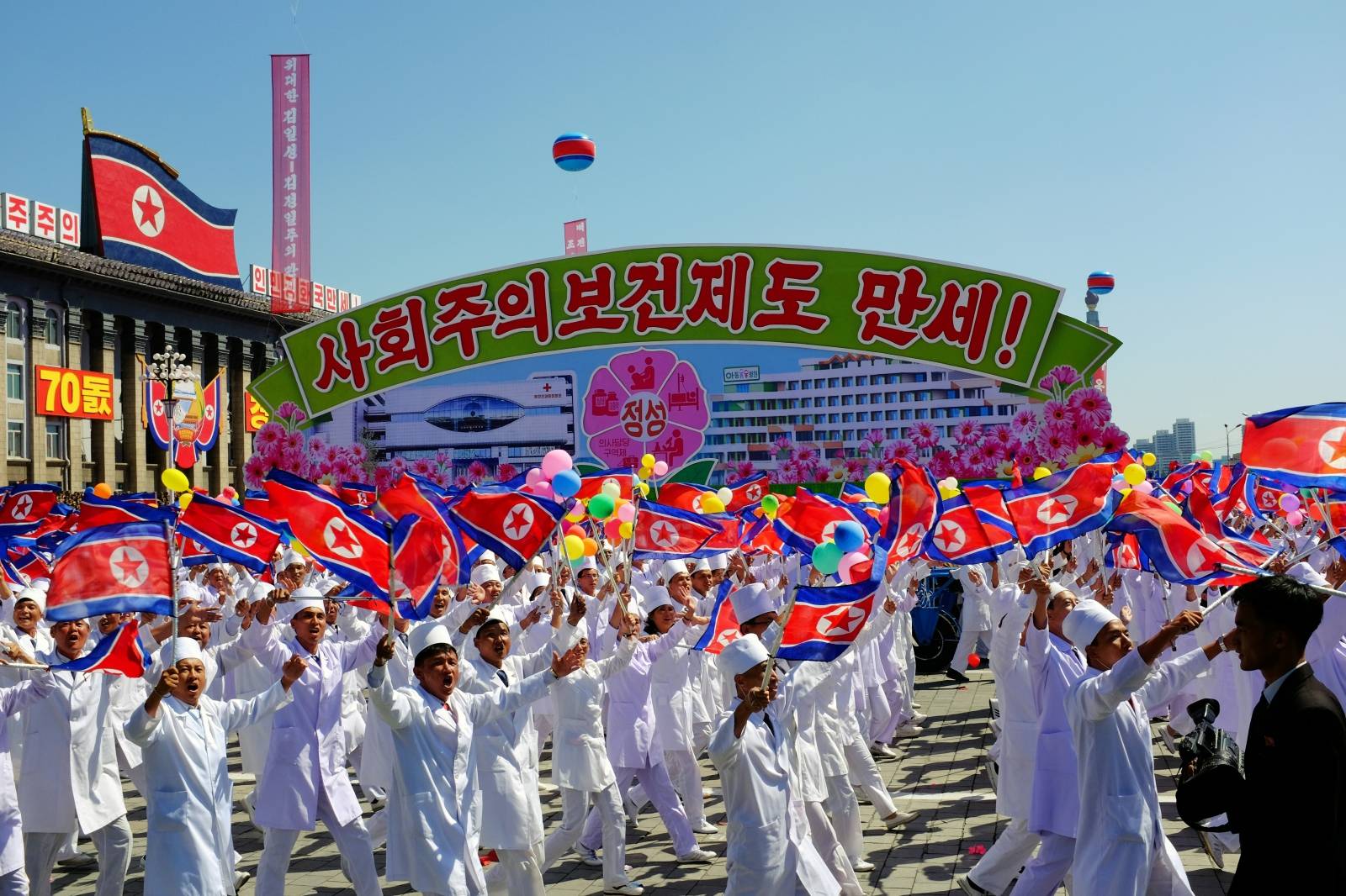 North Koreans march alongside a float celebrating the country’s socialist health system during a parade in Pyongyang