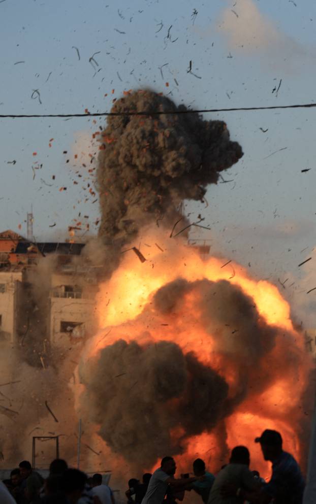 Smoke and flames rise as a residential building collapses after an Israeli air strike, in Gaza City