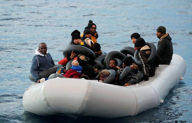 Migrants are seen on a dinghy following a failed attempt to cross to the Greek island of Lesbos, as a Turkish Coast Guard boat aproaches them, on the waters of the North Aegean Sea, off the shores of Canakkale