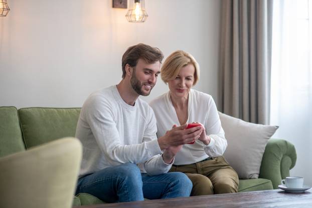 Young bearded man looking at the photos with his mom