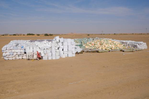 Food aid for internally displaced people from al-Fashir, provided by Qatar Charity, sit in a camp in  Al-Dabbah