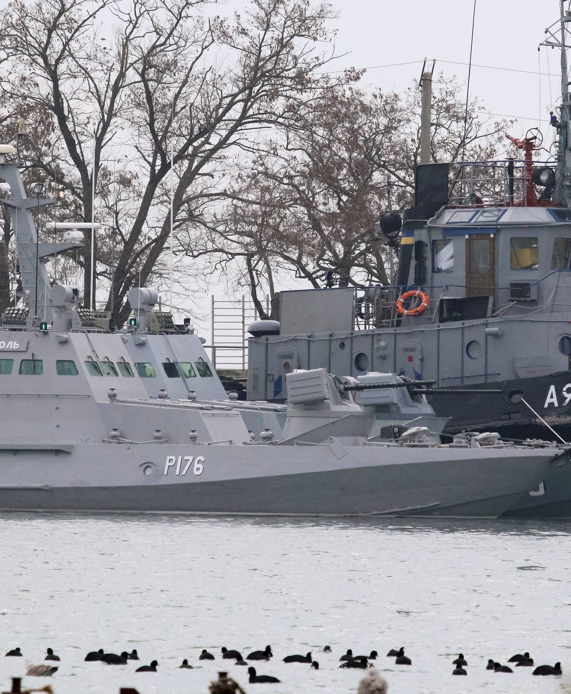 Seized Ukrainian ships, small armoured artillery ship and a tug boat, are seen anchored in a port of Kerch