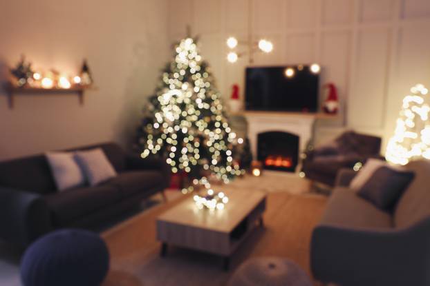 Blurred view of room with beautiful Christmas tree near fireplac