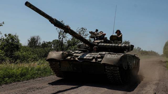 FILE PHOTO: Ukrainian servicemen ride in a T-80 main battle tank captured earlier from Russian troops, along a road near the front line town of Bakhmut