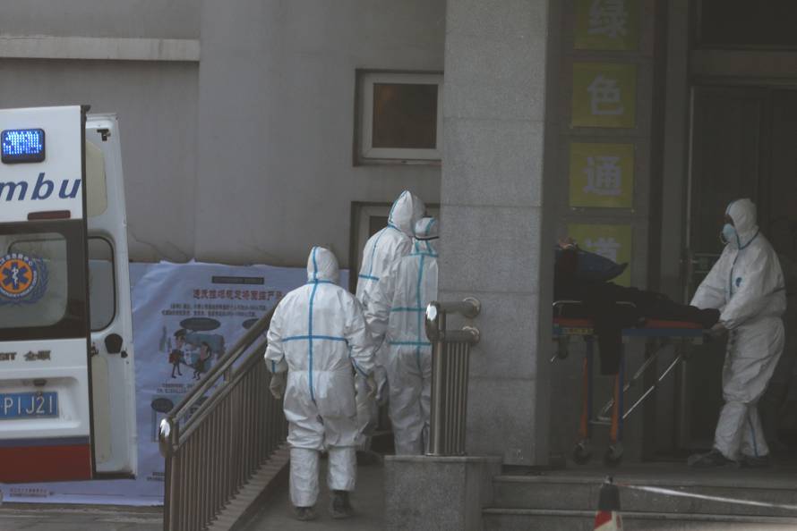 Medical staff transfer a patient from an ambulance at the Jinyintan hospital, where the patients with pneumonia caused by the new strain of coronavirus are being treated, in Wuhan