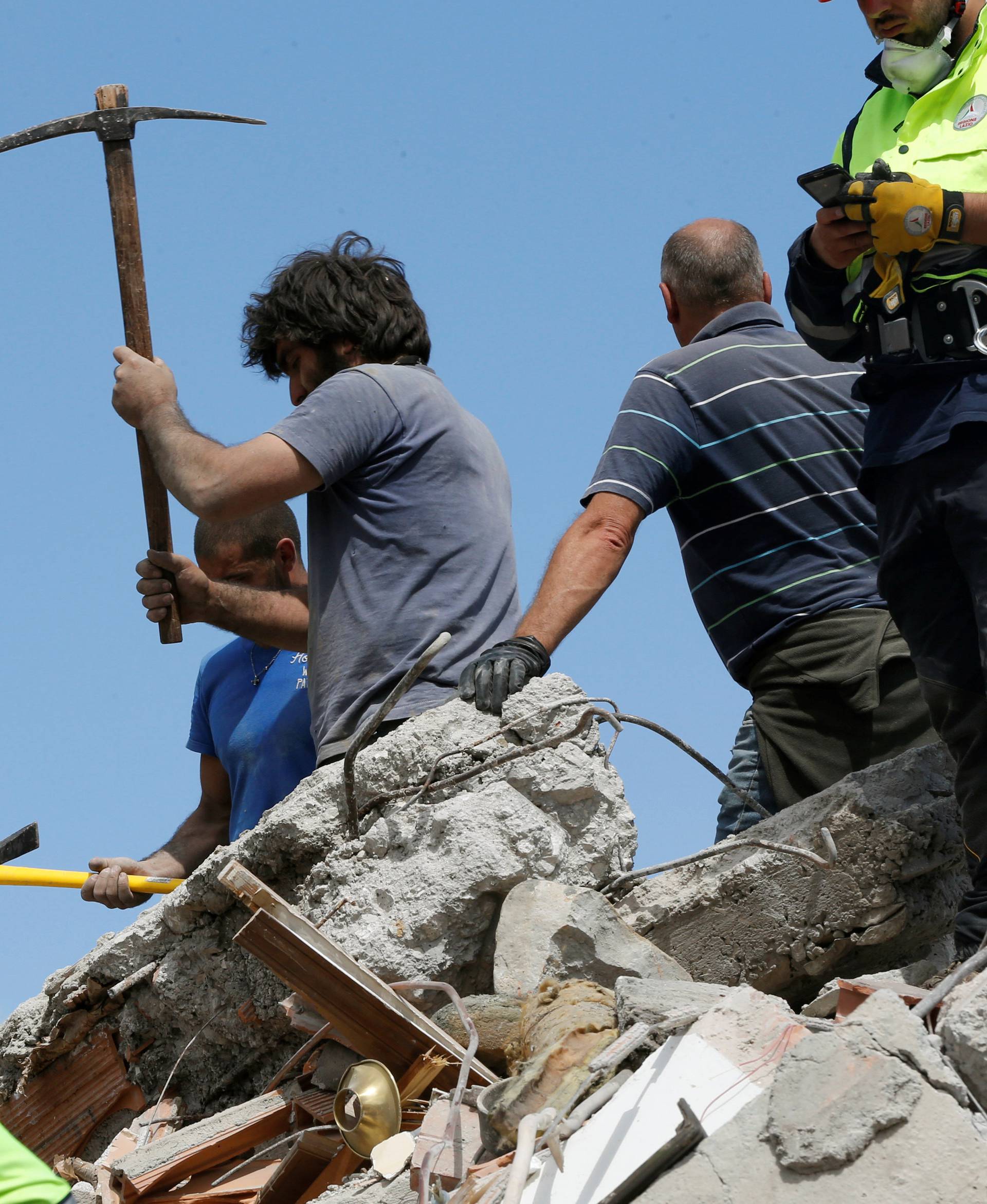 Rescuers work on a collapsed building following an earthquake in Amatrice