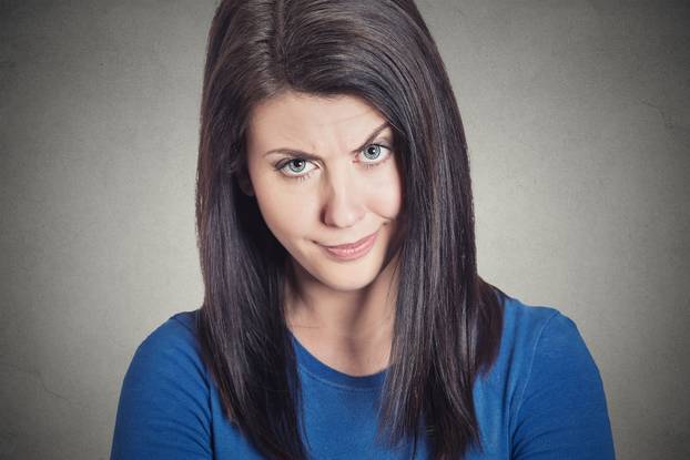 skeptical young woman looking suspicious with disgust on her face
