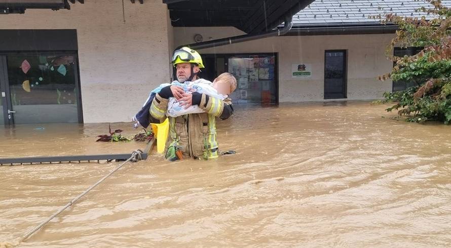 FOTO Vatrogasci spašavali djecu iz vrtića u Sloveniji, prestrašene ih iznosili u rukama po poplavi