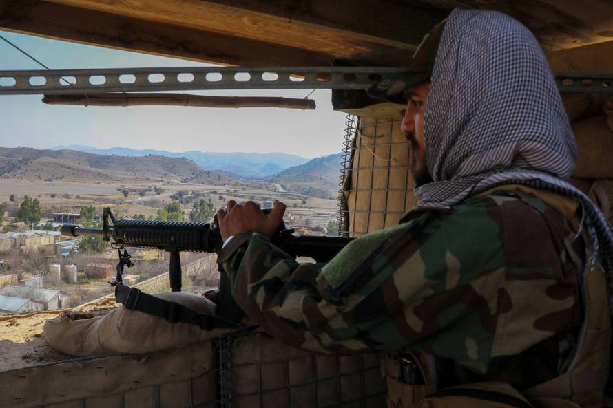 A Taliban soldier keeps vigil from inside his post near the Pakistan-Afghanistan border, in Khost province