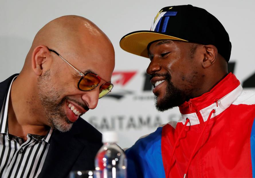 Boxer Floyd Mayweather Jr. of the U.S. talks with Brent Johnson from One Entertainment during a news conference in Tokyo