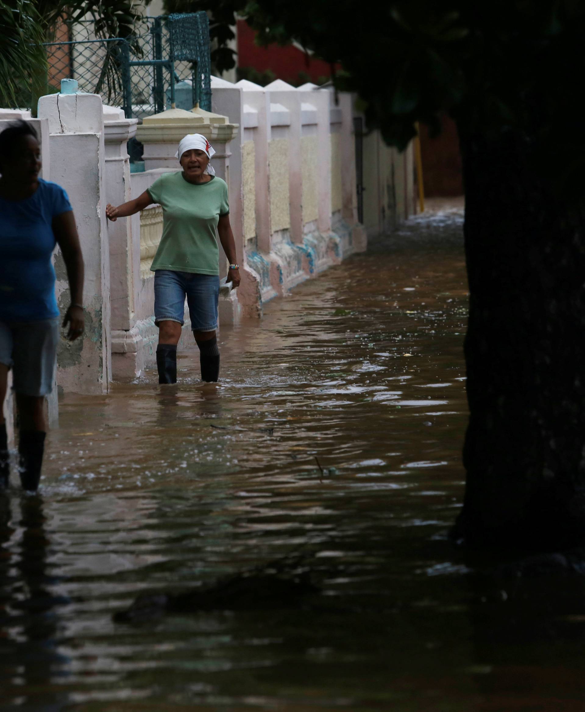 Women wade through a flooded street as Hurricane Irma turns toward the Florida Keys on Saturday, in Havana