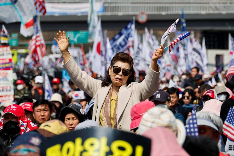Far-right protesters react after hearing that President Yoon Suk Yeol's impeachment was accepted, near his residence in Seoul