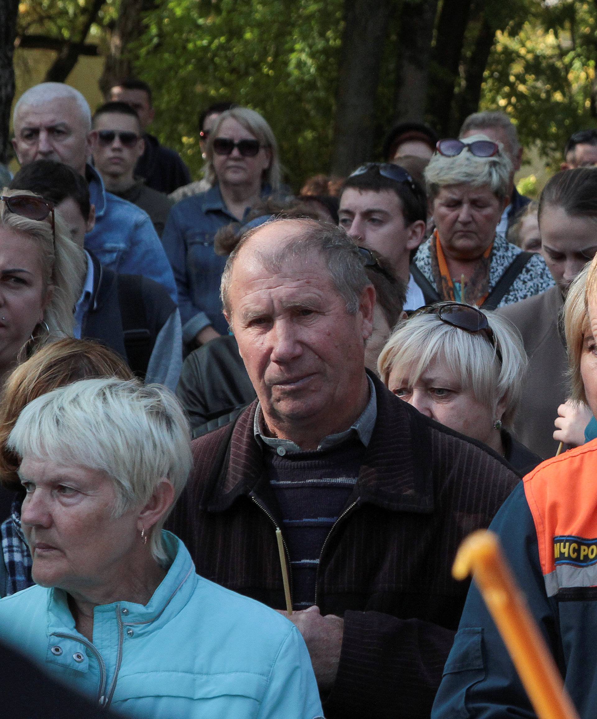 A priest conducts a memorial service for victims of an attack on a college in Kerch