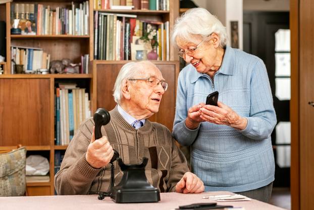 Grandfather,With,Old,Telephone,And,Grandmother,With,Smartphone