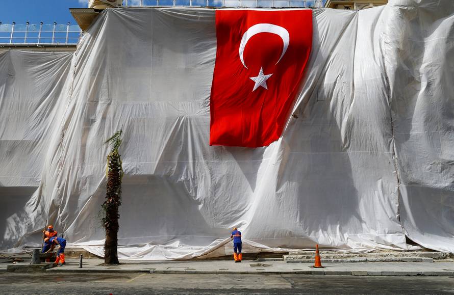 A building is seen covered and decorated with a Turkish flag after Tuesday's car bomb attack on a police bus, in Istanbul