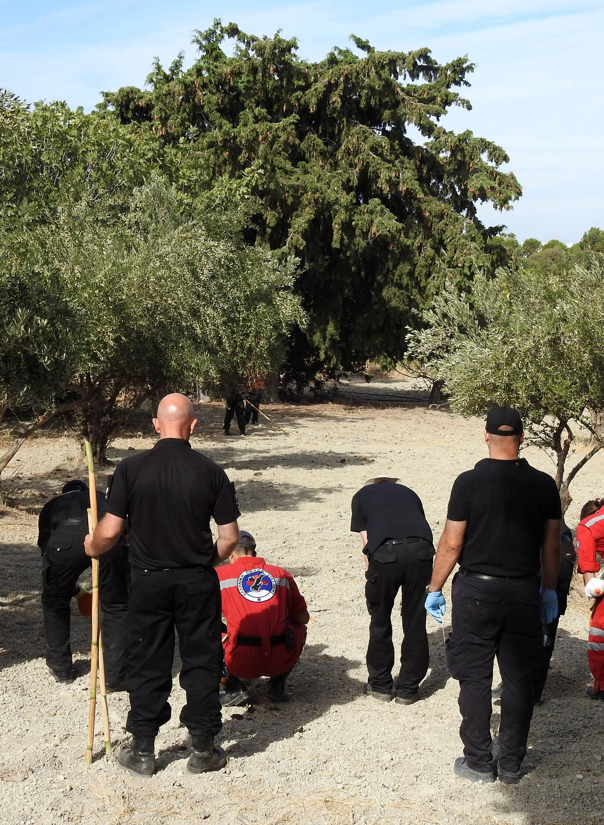 South Yorkshire police officers and members of the Greek rescue service (in red uniforms) investigate the ground before commencing excavating a site for Ben Needham, a 21 month old British toddler who went missing in 1991, on the island of Kos