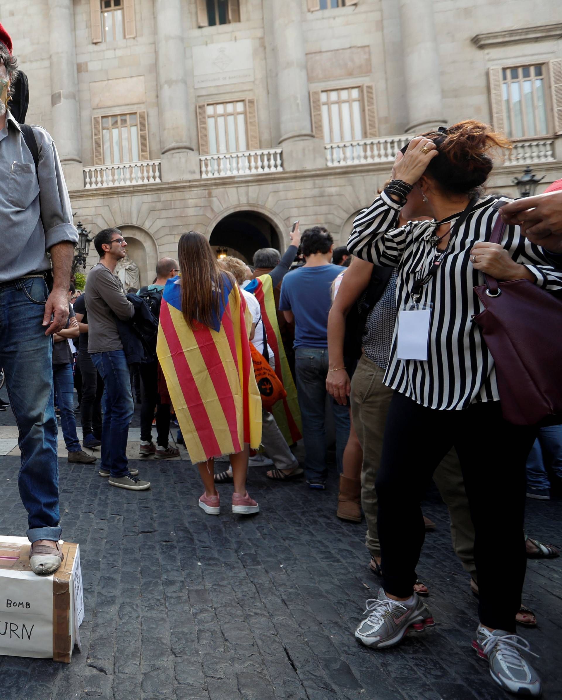 A man stages a performance in Plaza Sant Jaume after a protest called by pro-independence groups for citizens to gather at noon in front of city halls throughout Catalonia, in Barcelona