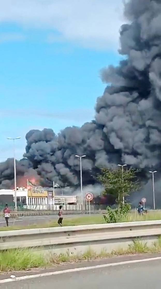 Smoke rises from a fire amid riots in Noumea