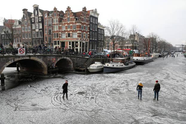 Ice skaters skate on the frozen Prinsengracht and Brouwersgracht canal during icy weather in Amsterdam