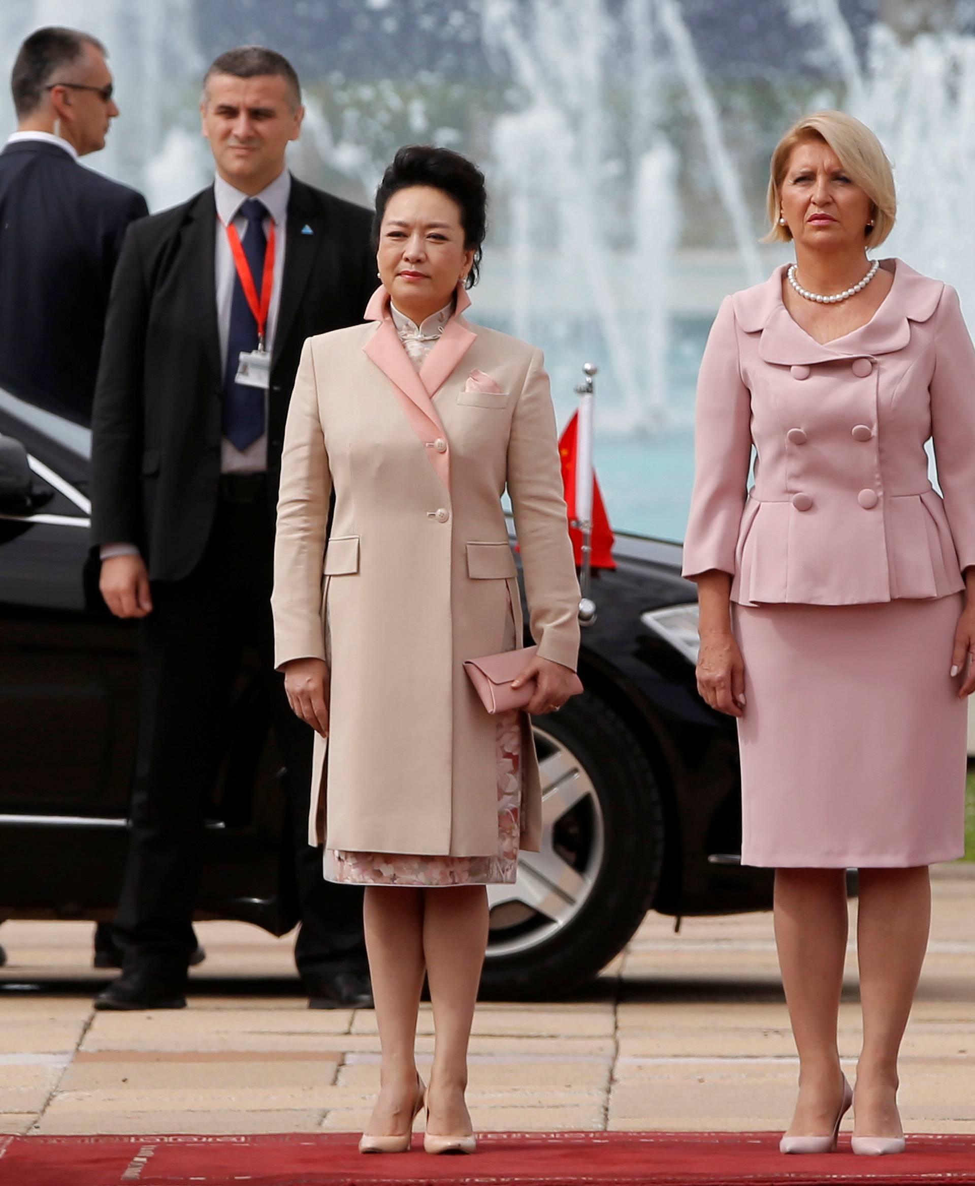 Chinese President Xi Jinping's wife Peng Liyuan (L) and Serbian President Tomislav Nikolic's wife Dragica listen to national anthems during a welcoming ceremony in Belgrade