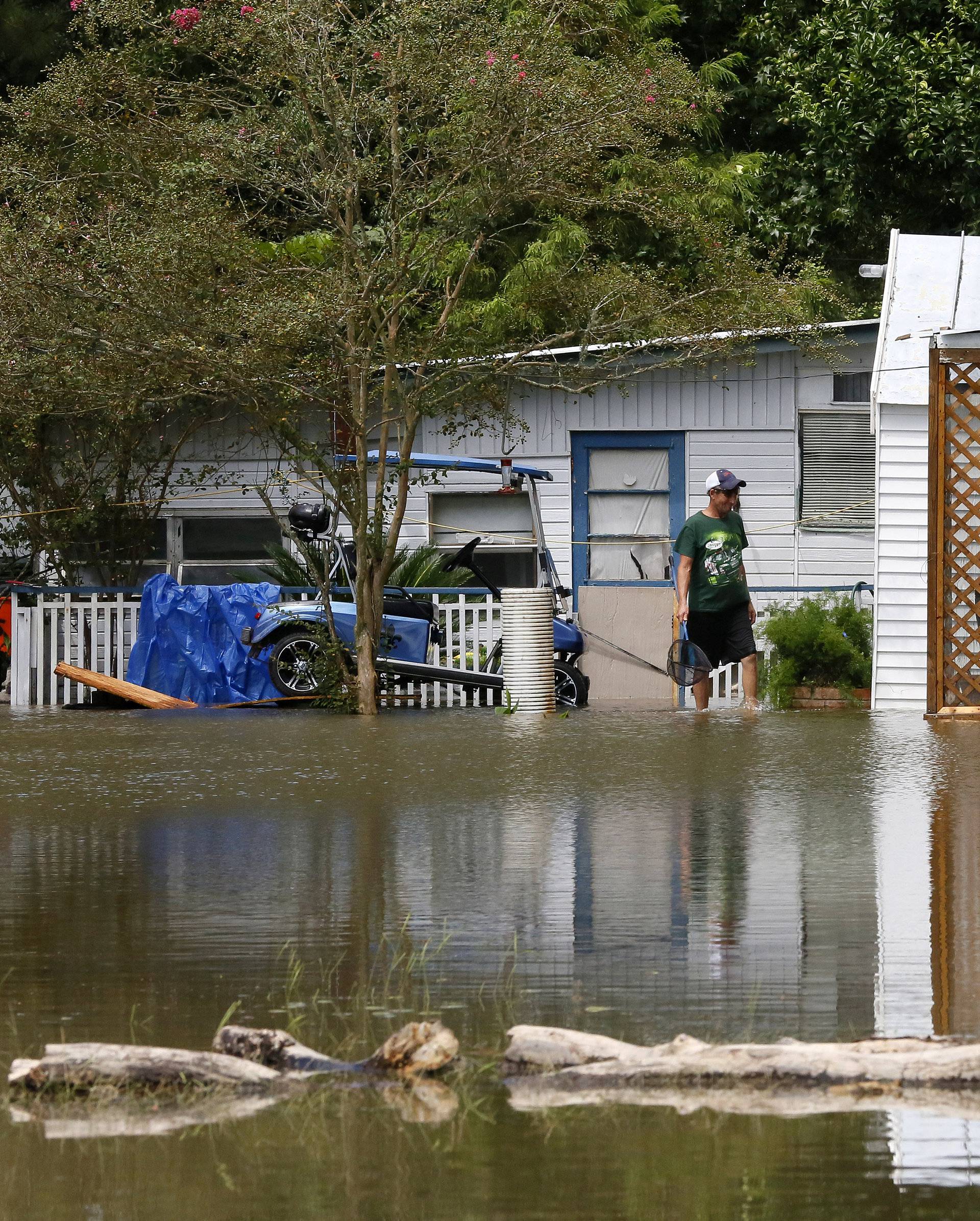 A man surveys a flooded home in St. Amant
