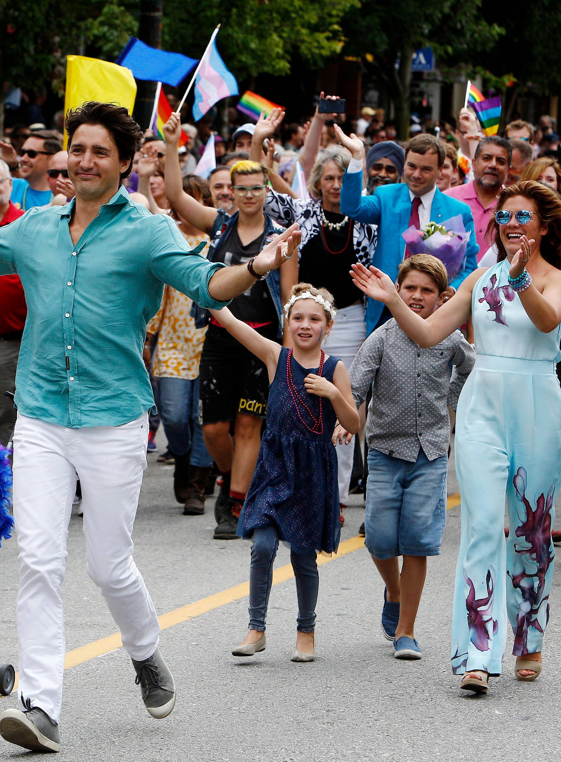 Canada's Prime Minister Justin Trudeau runs with his wife Sophie GrÃ©goire Trudeau and their children Hadrien (L), Ella-Grace and Xavier while participating in the Vancouver Pride Parade