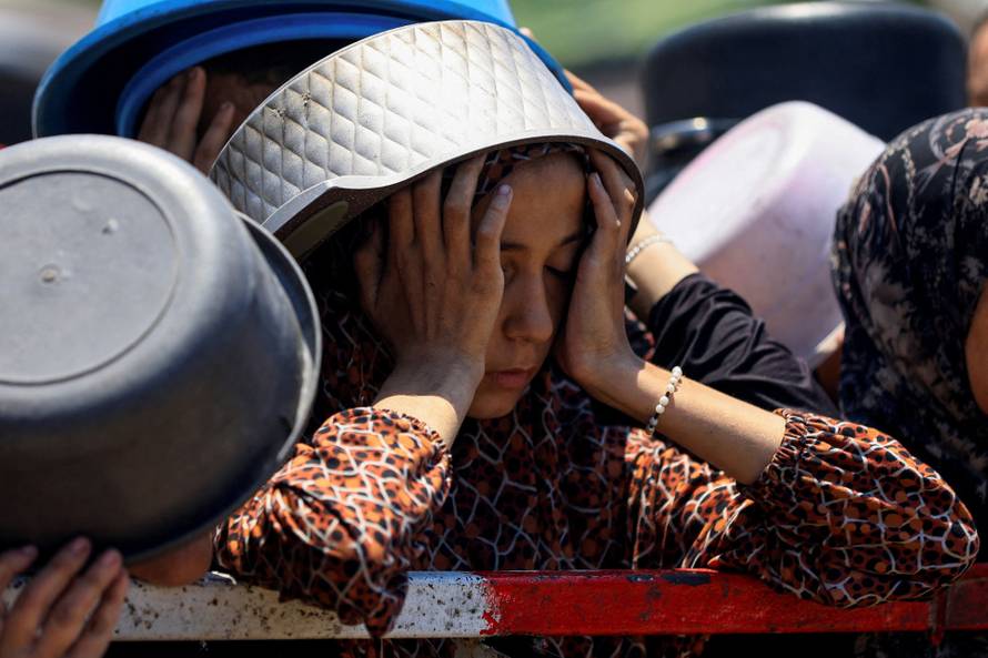 FILE PHOTO: Palestinians gather to receive food from charity kitchen, in Gaza City