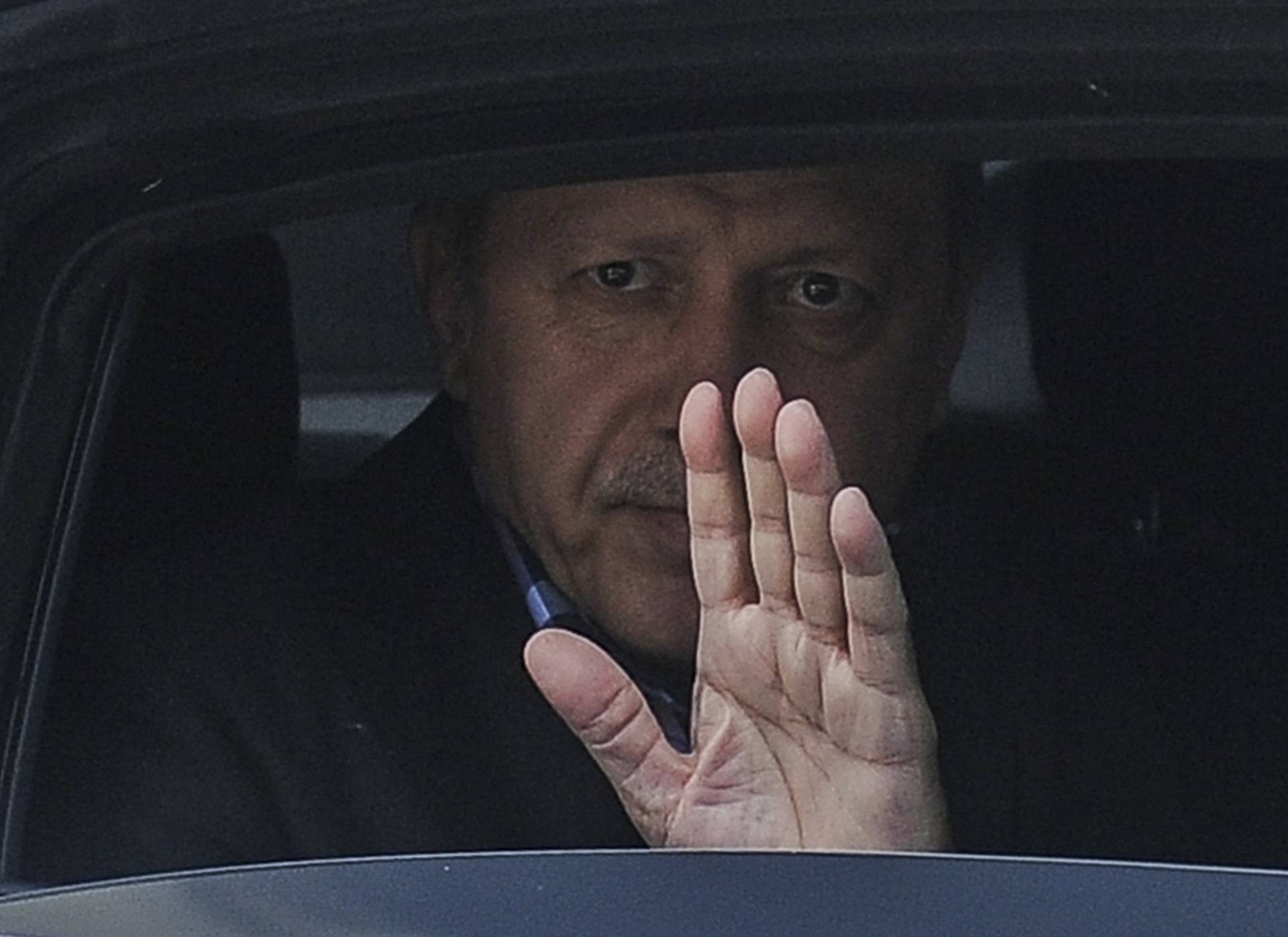 Turkish President Erdogan waves from his car after leaving his residence in Istanbul
