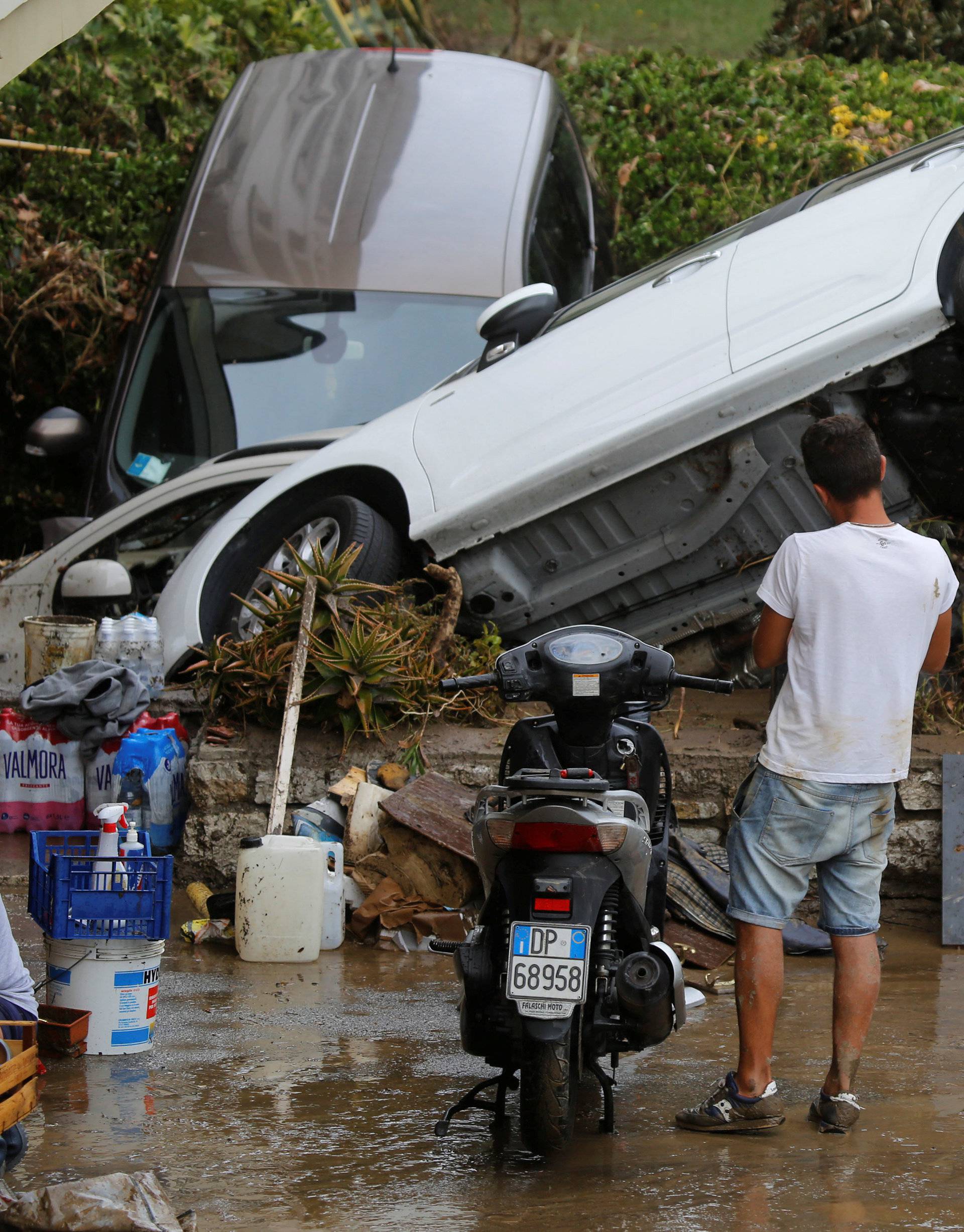 A man looks at damaged cars following floods in Livorno