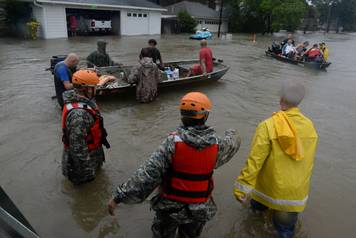 Texas National Guardsmen work alongside first responders to rescue local citizens from severe flooding in Cypress Creek