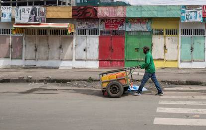 A man pushes a hand-cart past closed shops following protests in Addis Ababa