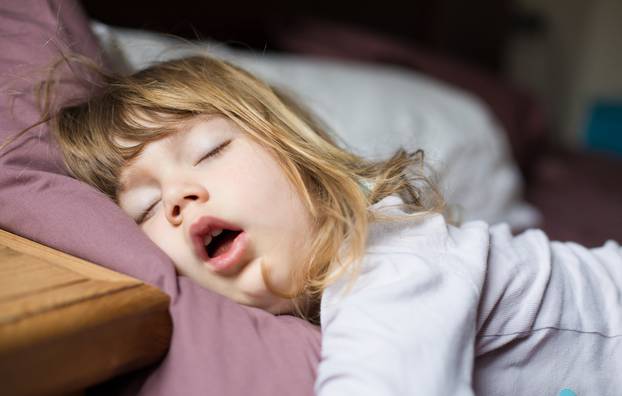 funny face of child sleeping on king bed