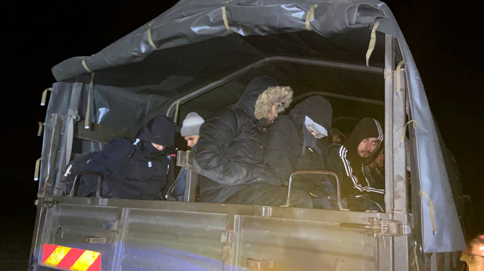 Migrants detained by Polish border guard wait in the military truck at the Poland/Belarus border near Kuznica