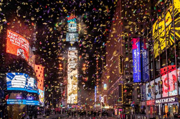 Confetti flies around the ball and countdown clock in Times Square during the virtual New Year