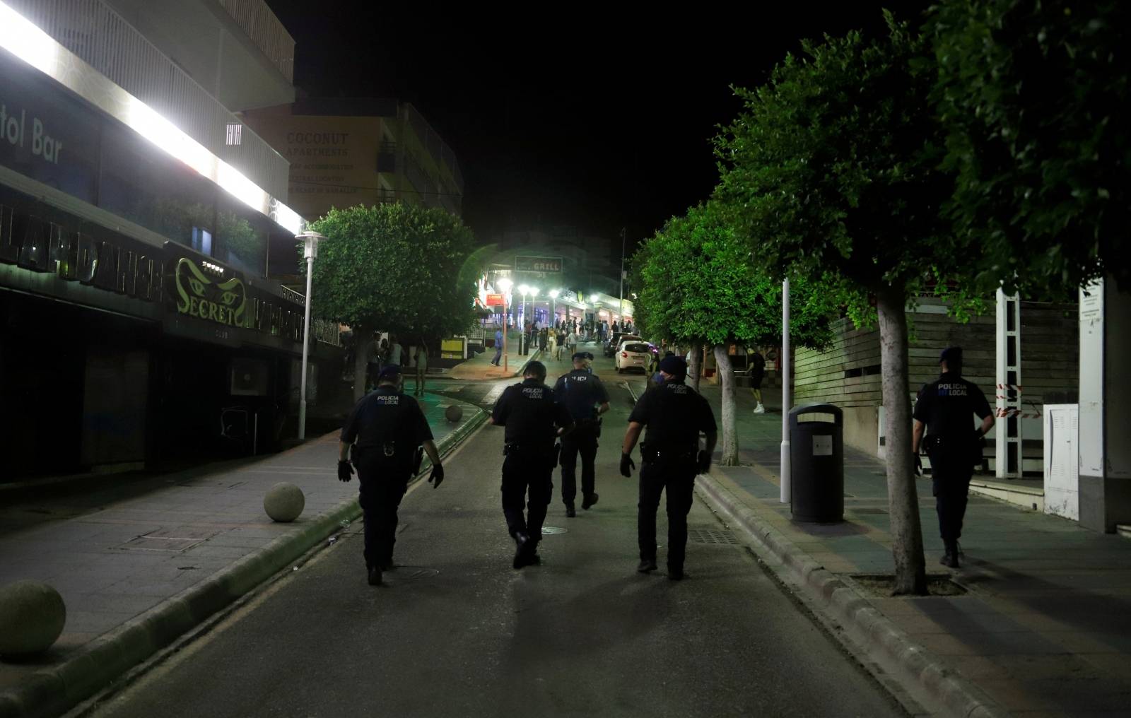 FILE PHOTO: Police officers wearing protective masks patrol in Punta Ballena street in Magaluf