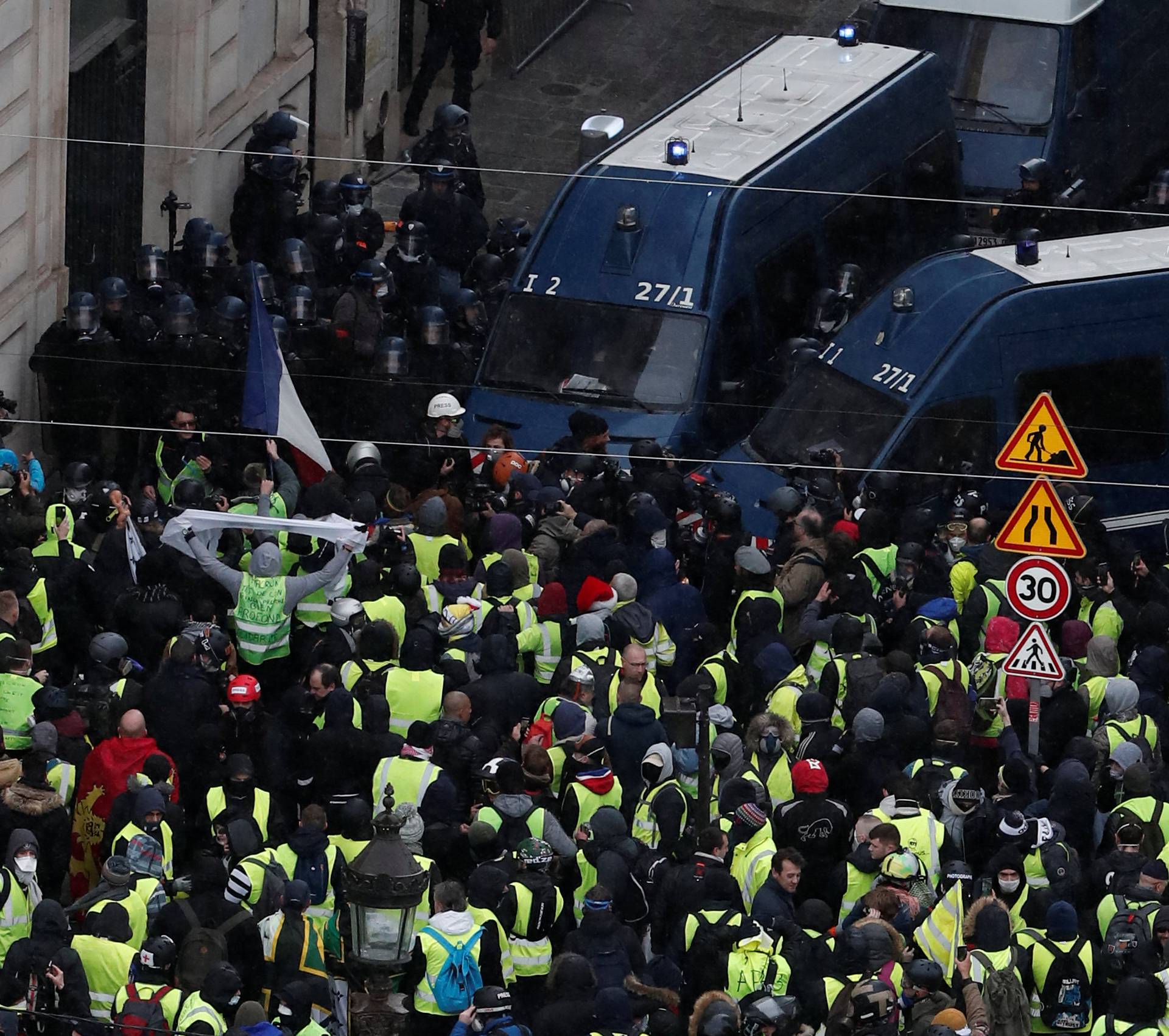 Protesters wearing yellow vests face off with French Gendarmes on the Champs-Elysees Avenue during a demonstration by the "yellow vests" movement in Paris