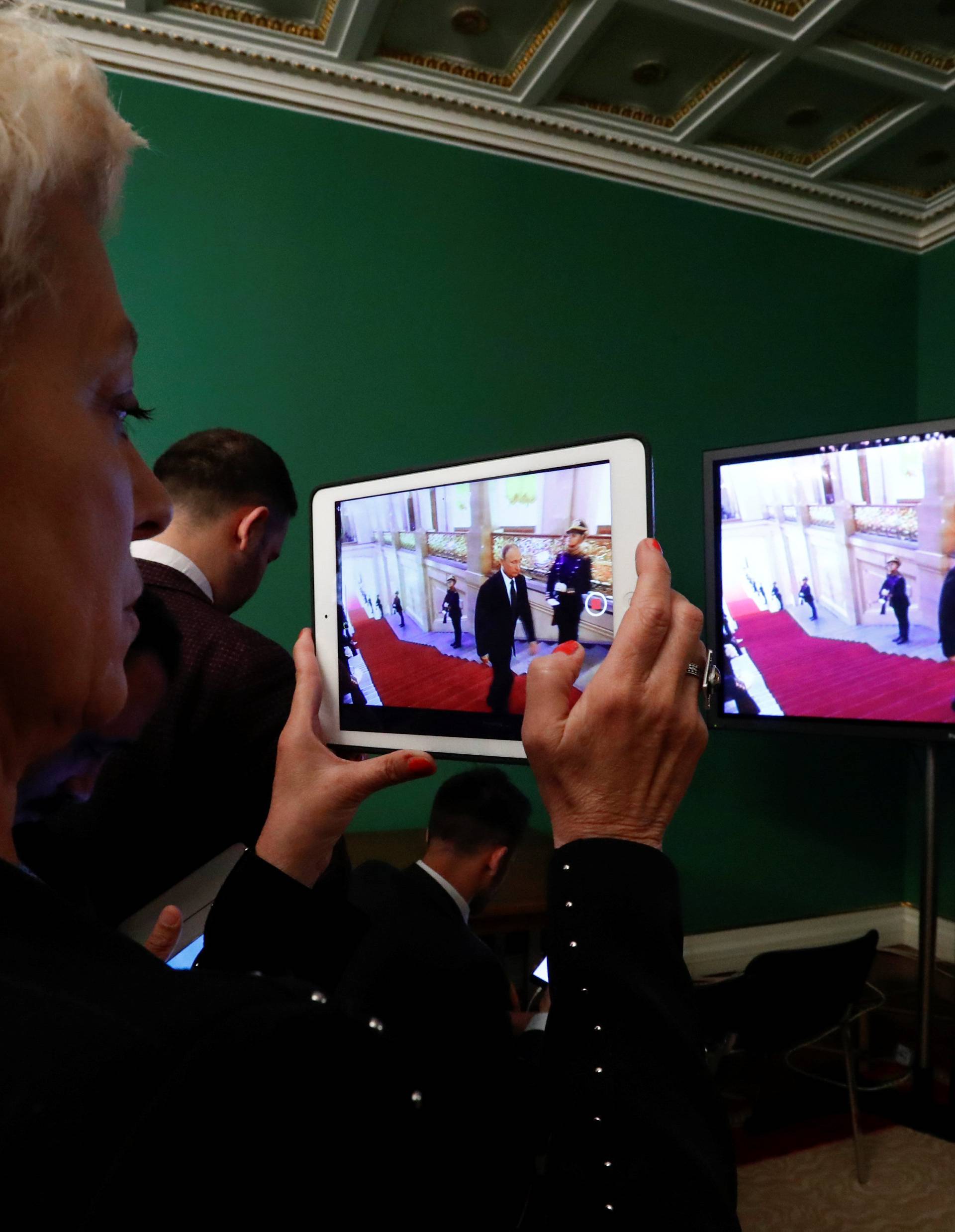 A journalist watches a ceremony to inaugurate Vladimir Putin as President of Russia at a press centre in Moscow