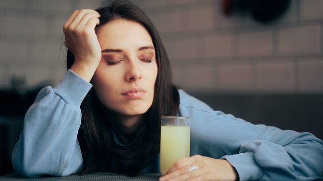 Tired Woman Having An Effervescent Drink Of Calcium And Magnesiu