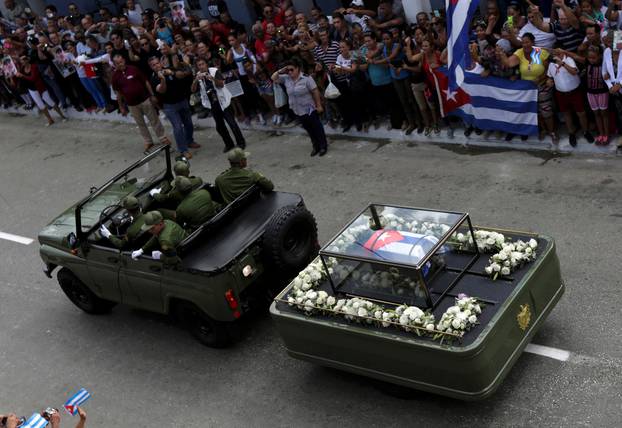 People line a road as they await the caravan carrying Fidel Castro