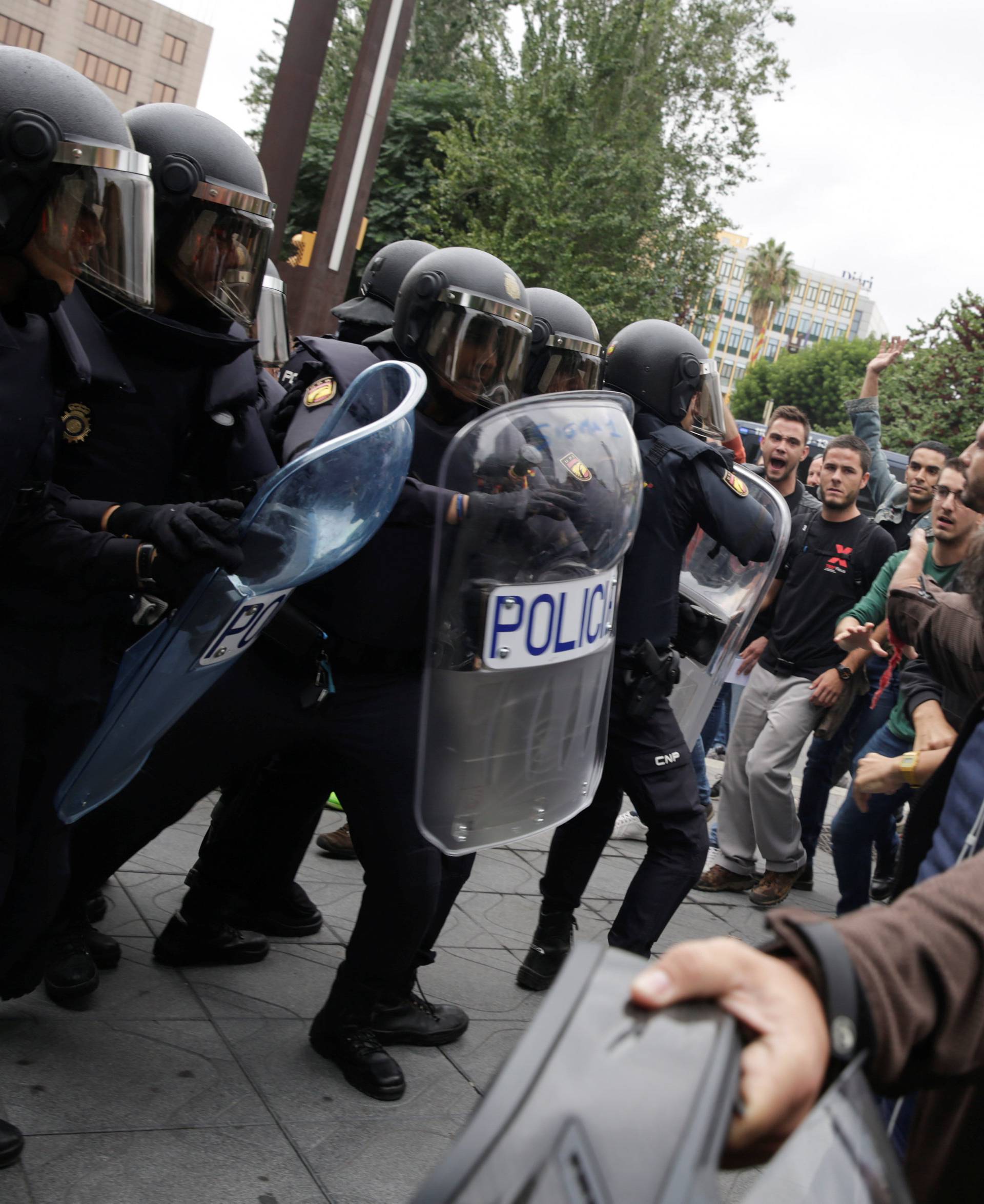 Spanish police confront people outside a polling station for the banned independence referendum in Tarragona