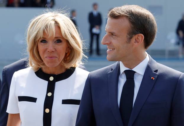 French President Emmanuel Macron and his wife Brigitte Macron leave after the traditional Bastille Day military parade on the Champs-Elysees avenue in Paris